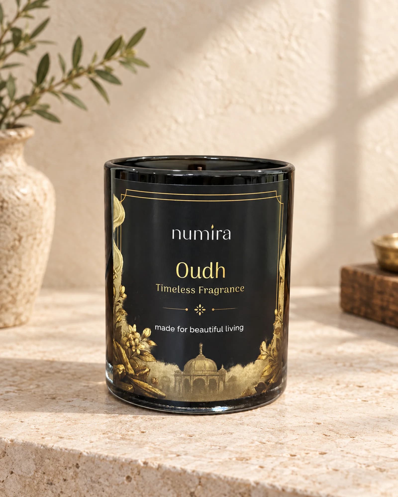 Oudh scented candle in black glass with gold floral artwork on its label