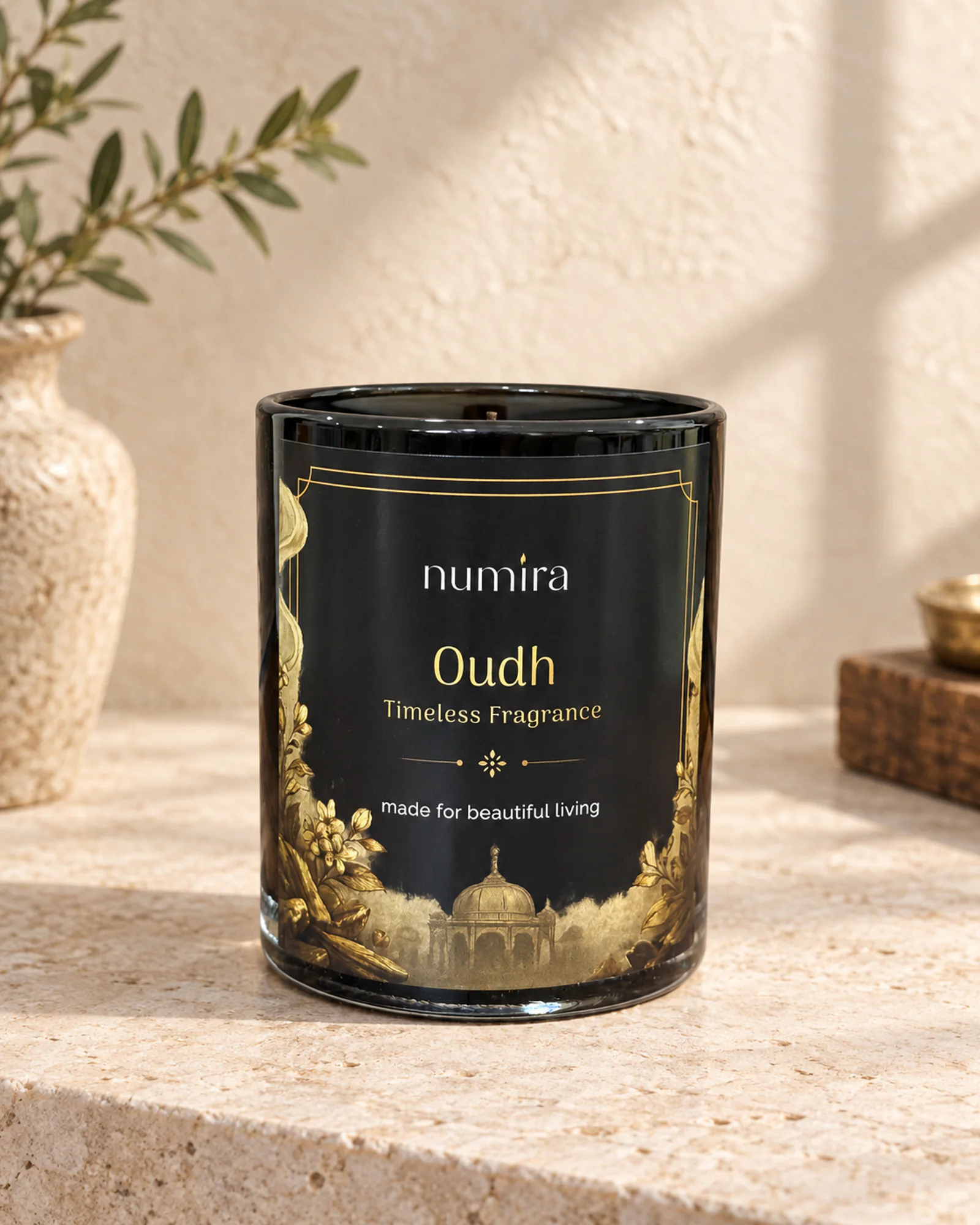 Oudh scented candle in a glossy black glass jar